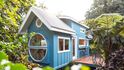 Dům Oasis Tiny House, obložený modrozelenou malovanou překližkou a kovovou střechou, navrhli a postavili sourozenci Ellie a Dan Madsenovi v Keaau na Havaji.