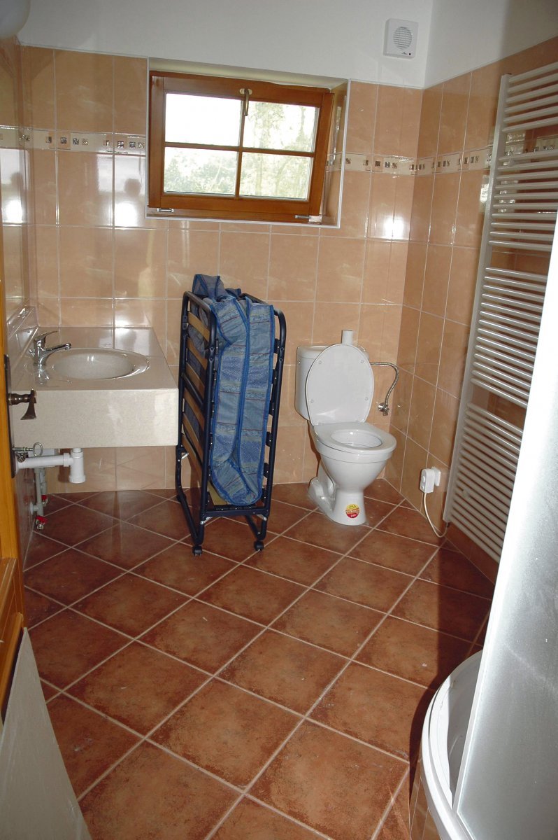 Koupelna s umyvadlem, toaletou a sprchou v bungalovu