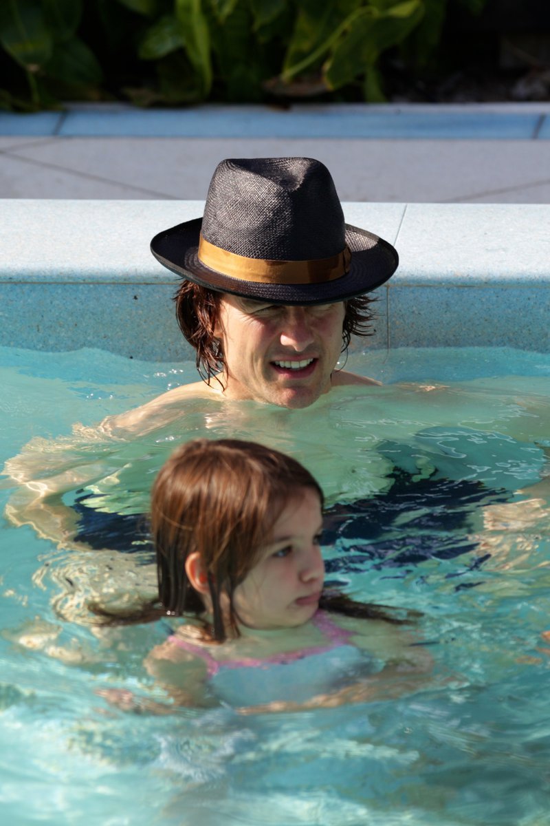 Táta Cruise učí Suri plavat v bazénku.