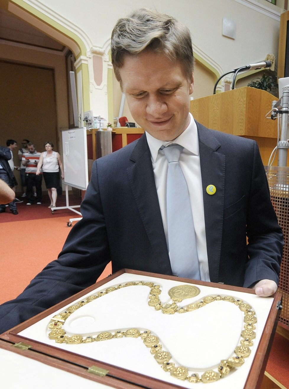 Tomáš Hudeček si po zvolení primátorem prohlíží primátorský řetěz. Připomíná mu prý řetěz z Pána prstenů