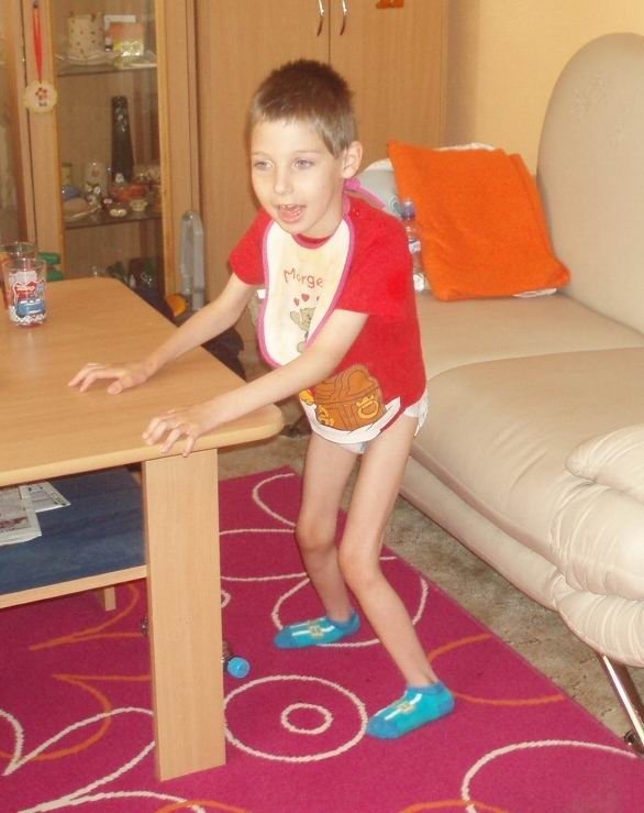 Tomášek Doubrava (7) nemůže chodit a snaží se postavit na nohy alespoň pomocí stolu.