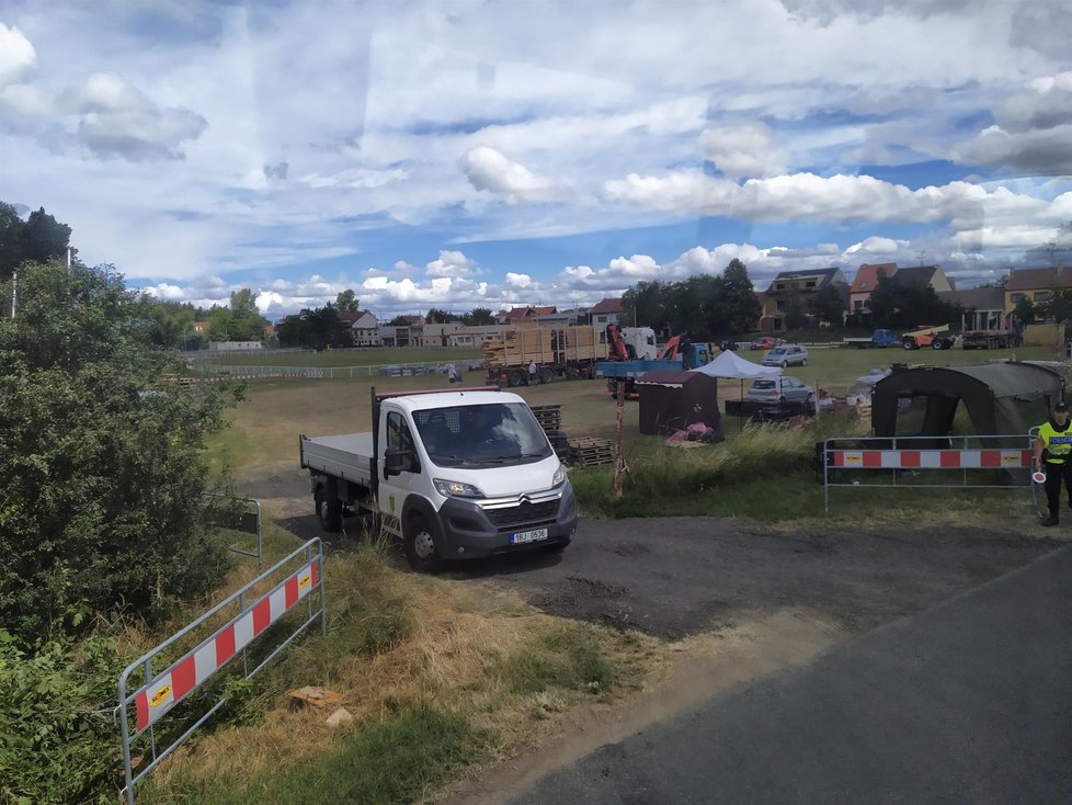 Na kraji Hrušek u fotbalového hřiště zřídila obec shromaždiště stavebního materiálu. Na provoz tam dohlíží policisté (3. 7. 2021).