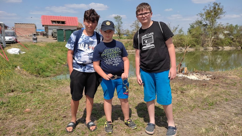 Trojice pomocníků, zleva Petr (11), Jakub (8) a Daniel (12). Skupina chlapců pomáhá lidem v tornádem poničených Hruškách.