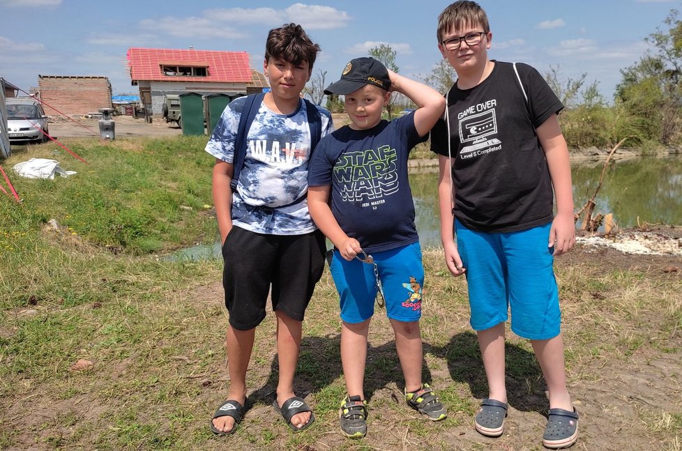 Trojice pomocníků, zleva Petr (11), Jakub (8) a Daniel (12). Skupina chlapců pomáhá lidem v tornádem poničených Hruškách.