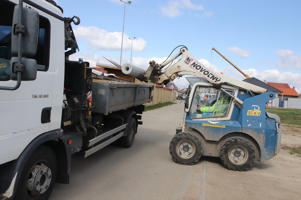 Nakladač odváží k nákladnímu autu rozřezané betonové sloupy, které v Hruškách sloužili pro provizorní osvětlení.