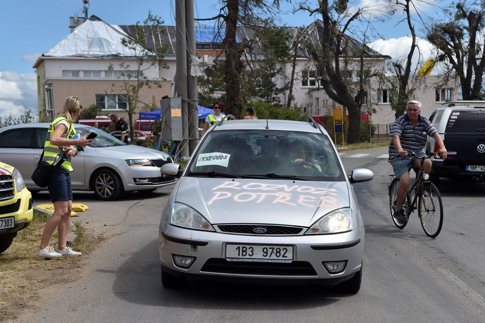 Dobrovolníci v Moravské Nové Vsi pomáhají s úklidem trosek a škod způsobených tornádem.