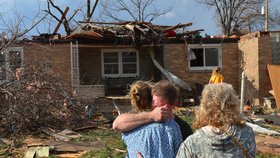 Rodina stojí před svým zcela zdevastovaným domem.
