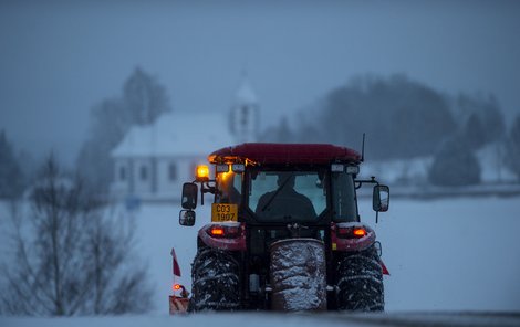 Traktor shrnuje sníh na silnici na Prachaticku. Na celém území Jihočeského kraje silně sněžilo.