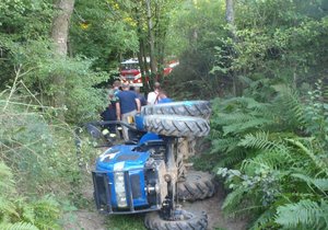 Traktor se převrátil na lesní cestě a zavalil řidičku.