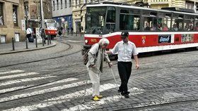 Řidič tramvaje zastavil tramvaj v křižovatce, aby pomohl stařence přejít.