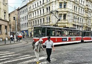 Řidič tramvaje zastavil tramvaj v křižovatce, aby pomohl stařence přejít.