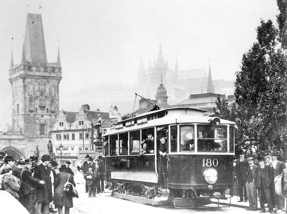 Tramvaj se spodním odběrem proudu jede po Karlově mostě.