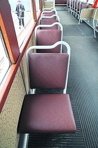 Uvnitř na cestující čekají hnědé koženkové sedačky, původní interiér doplňují moderní terminály a informační prvky