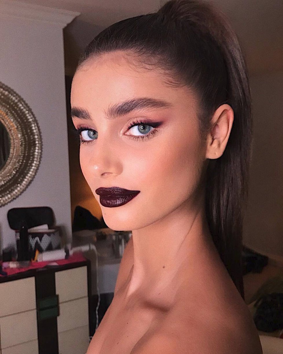 Taylor Hill s temně švestkovou rtěnkou.