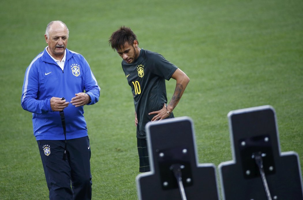 Brazilský útočník Neymar pilně trénuje přímé kopy, dohlíží na něj trenér Scolari.