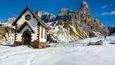 Malý kostelík v průsmyku Passo Rolle se choulí u paty zdejší druhé nejvyšší hory Cimon della Pala.