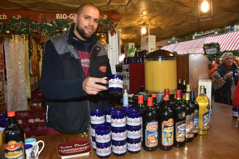 Norimberk: Prodavač Randy (35) ve stánku s&nbsp;teplými nápoji ukazuje tradiční hrníček na svařák pro rok 2022.