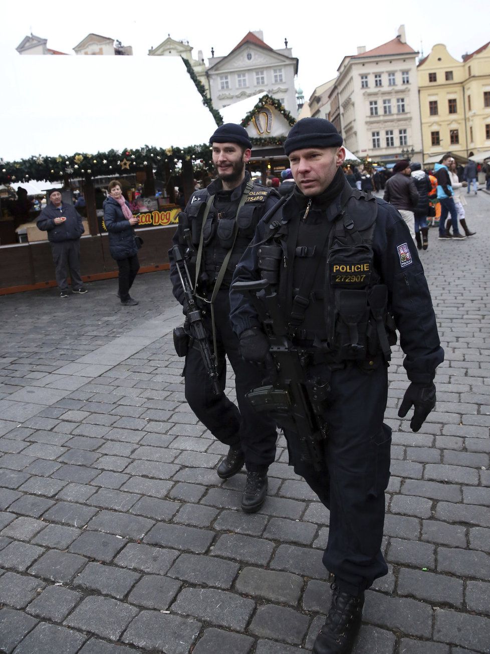 Po trzích na Staroměstském náměstí v Praze se procházejí policisté se samopaly.