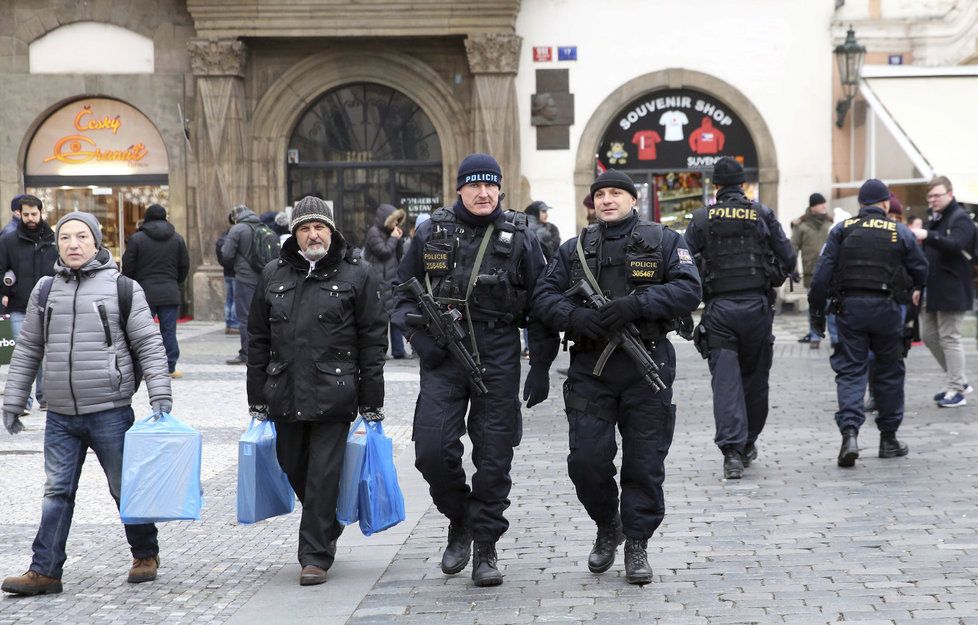 Po trzích na Staroměstském náměstí v Praze se procházejí policisté se samopaly.