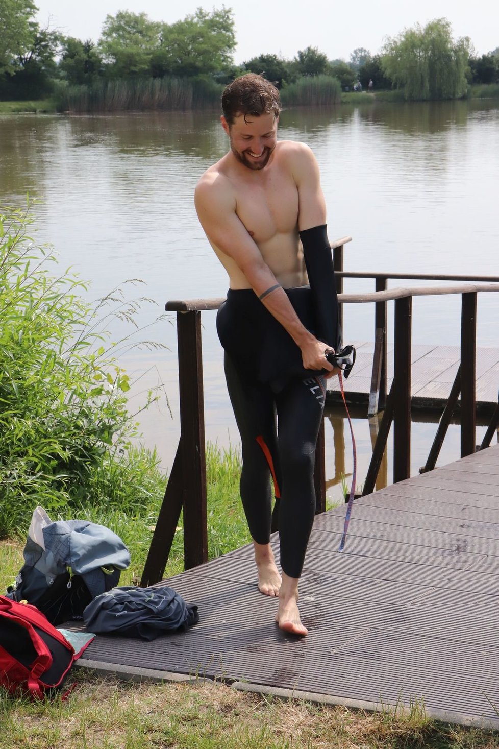 Jakub Žák (27) se svléká z neoprénupo závěrečném plaváním na 1,9 km v Rakvicích.