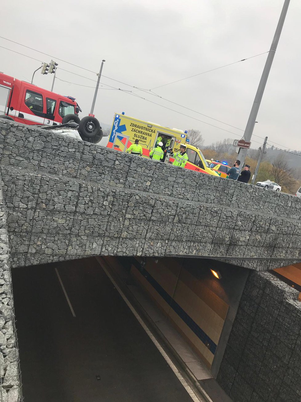 Auto se na Trojském mostě převrátilo na střechu.