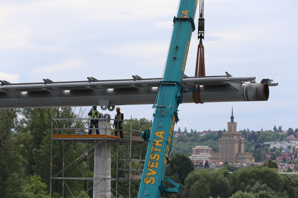 Dokončení usazení mostovky na pilíře nové trojské lávky.