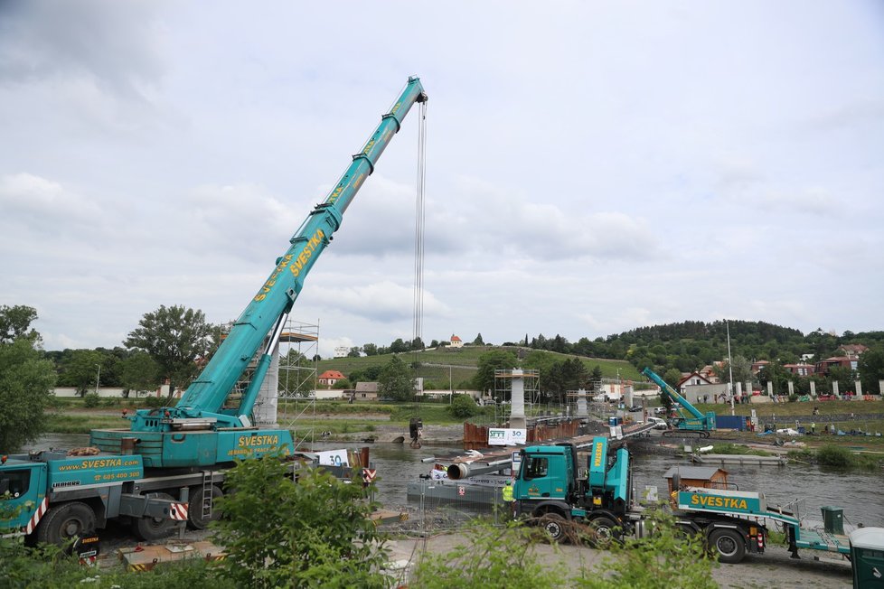 Dokončení usazení mostovky na pilíře nové trojské lávky.