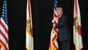 Ještě jako republikánský kandidát na prezidenta objímá Donald Trump americkou vlajku při vstupu na pódium. Chystá se promluvit v amfiteátru MidFlorida Credit Union v Tampě na Floridě.