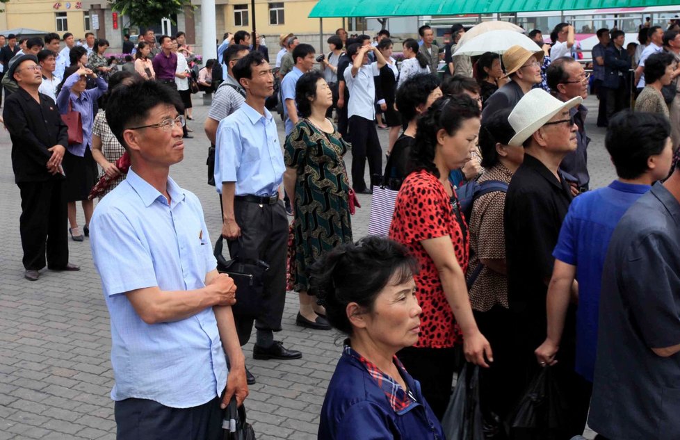 V hlavním městě Severní Koreje lidé napjatě sledují velkoplošné obrazovky, na kterých jim zatím ukázali setkání jejich vůdce Kima se singapurským premiérem Lee Hsien Loongem.