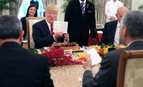 Trump ukazuje hostům menu.