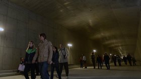 Lidé procházejí rozestavěným tunelem Blanka, obklopeni tunami betonu