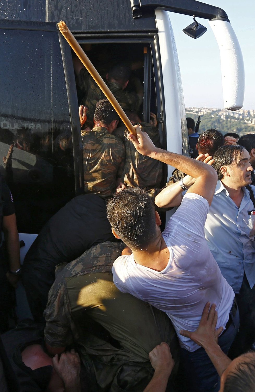 Vojáci z řad rebelů se snaží dostat do autobusu, rozhořčený dav je lynčuje.