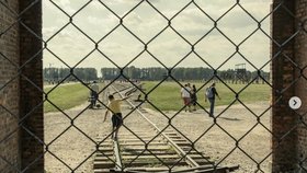 Turisté pózující na kolejích vedoucích do bývalého koncentračního tábora Osvětim-Březinka.