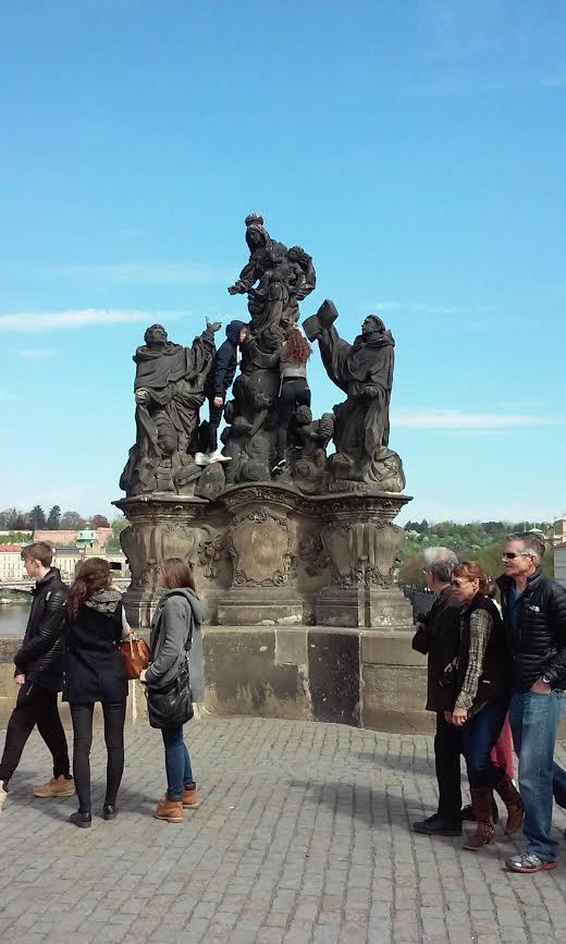 Turisté chtěli mít hezkou památku na Prahu, vylezli na sochu a nechali se vyfotit.