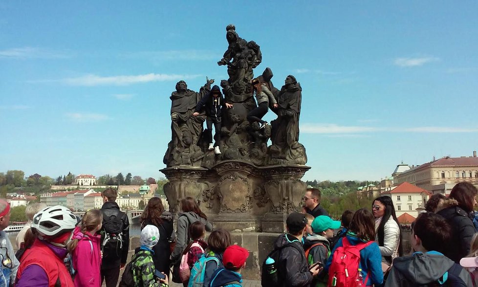 Turisté chtěli mít hezkou památku na Prahu, vylezli na sochu a nechali se vyfotit.