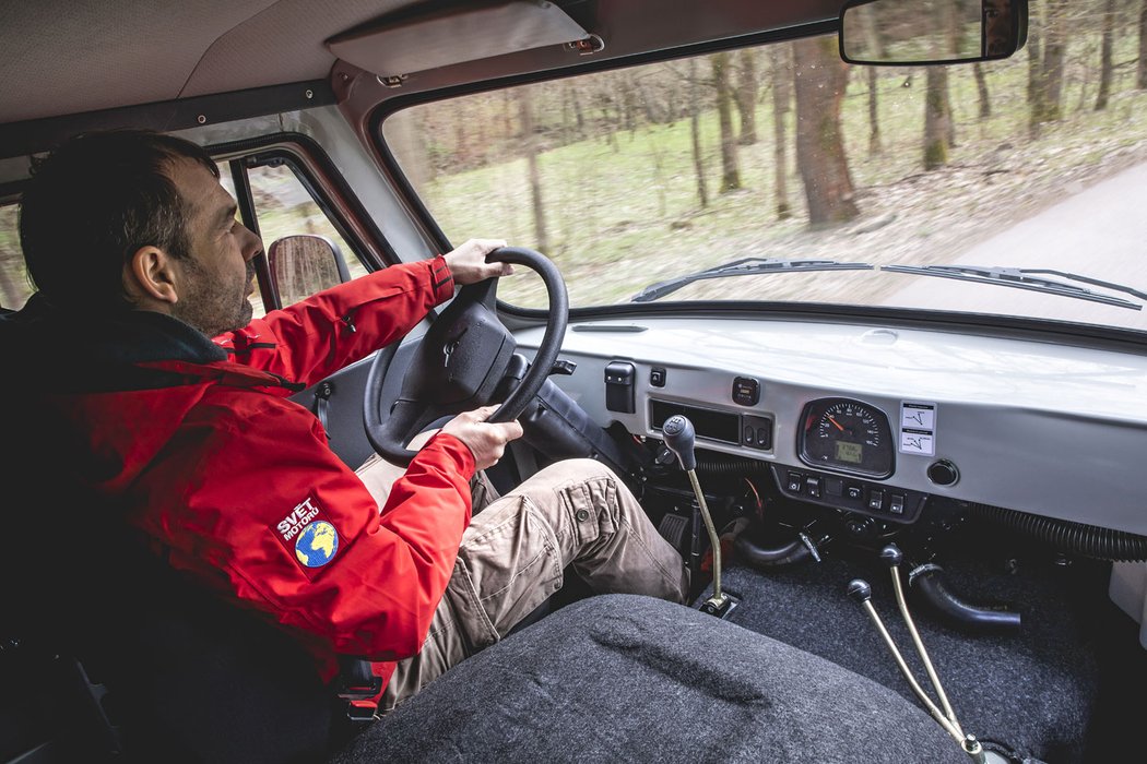 Na této fotce je všechno. Řadicí páka ve snadném dosahu, dvojice pák pohonu 4x4 a redukce naopak hodně daleko, tachometr uprostřed a pod ním samotné topení s hlučným ventilátorem. Naprostou saunu však uvnitř udělá už pouhým náporovým prouděním vzduchu.