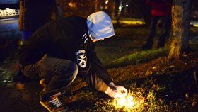 Mladík zapaluje svíčku nedaleko restaurace v Uherském Brodu, kde střelec zabil osm lidí.