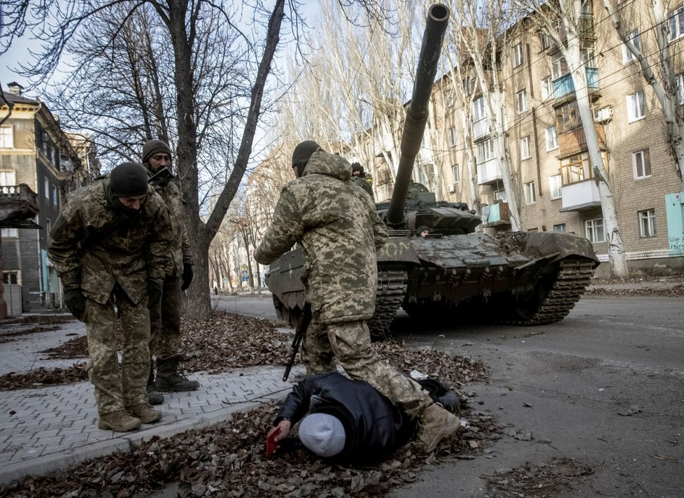 Příslušníci ukrajinské služby prohledávají místního obyvatele během jeho zadržení v Bachmutu (8.12.2022))