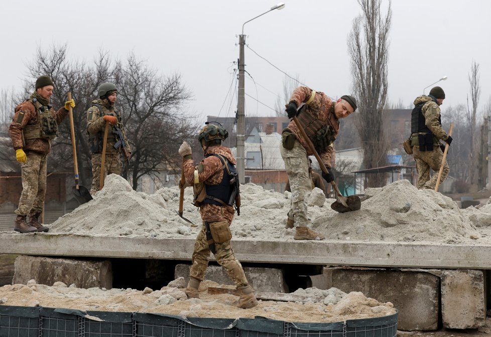 Ukrajinští vojáci budují improvizovaný bunkr z písku. (Bachmut, 26. 12. 2022).