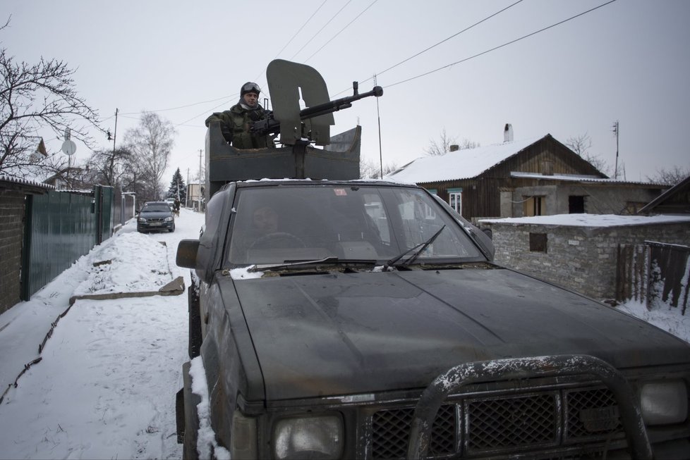 Proruský rebel se zbraní objíždí v dodávce město Vuhlehirsk na východní Ukrajině