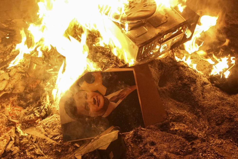 Demonstrující podpalují fotografie prezidenta Viktora Janukovyče.