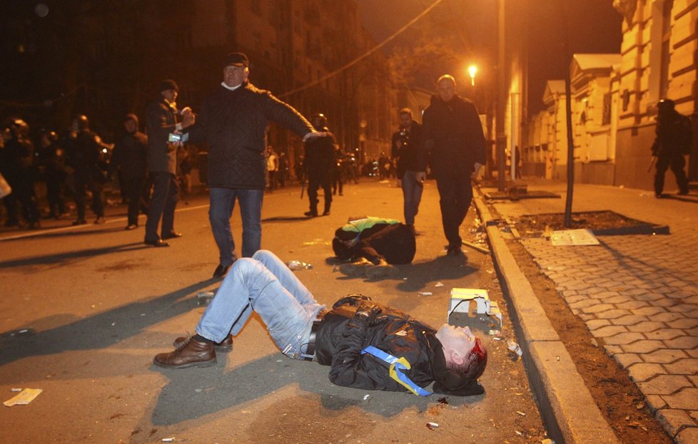 Během střetů těžkooděnců a demonstrantů zůstala na ulicích řada zraněných