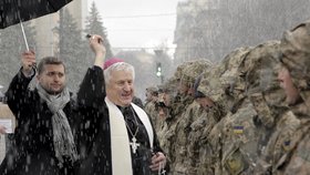 Katolický kněz žehná ukrajinským vojákům, kteří jdou bojovat proti svým spoluobčanům na východě země.