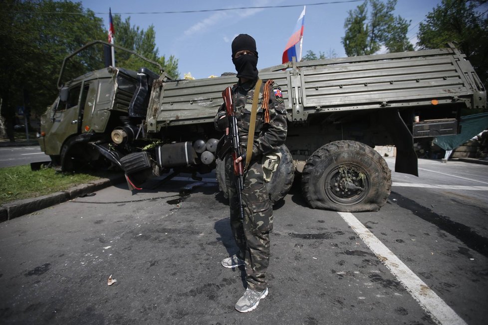 Doněcký separatista před poničeným náklaďákem