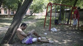 Zraněný muž ukrytý na dětském hřišti si volá pomoc.