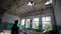 Policista obhlíží rozbombardovanou školu v Marince v Doněcké oblasti (31. 5. 2022).