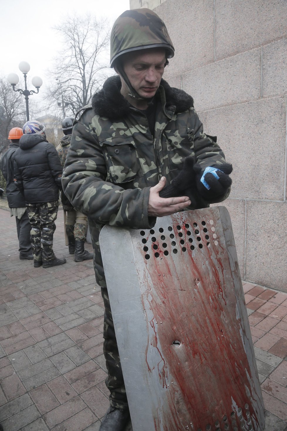 Ukrajinský demonstrant se zakrváceným štítem