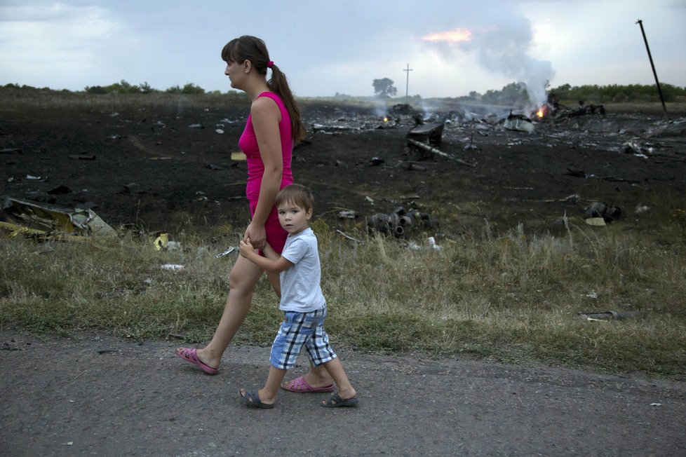 Maminka vede své dítě na cestě u místa, kde se zřítil letoun MH17.