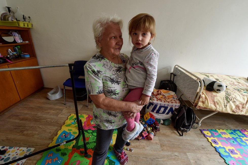Ukrajinka Valentina Strohanovová drží v náručí svoji vnučku v pokoji v bývalé budově kasáren v Místeckém lese ve Frýdku-Místku.