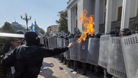 Jeden z demonstrantů útočí na policisty ohněm.